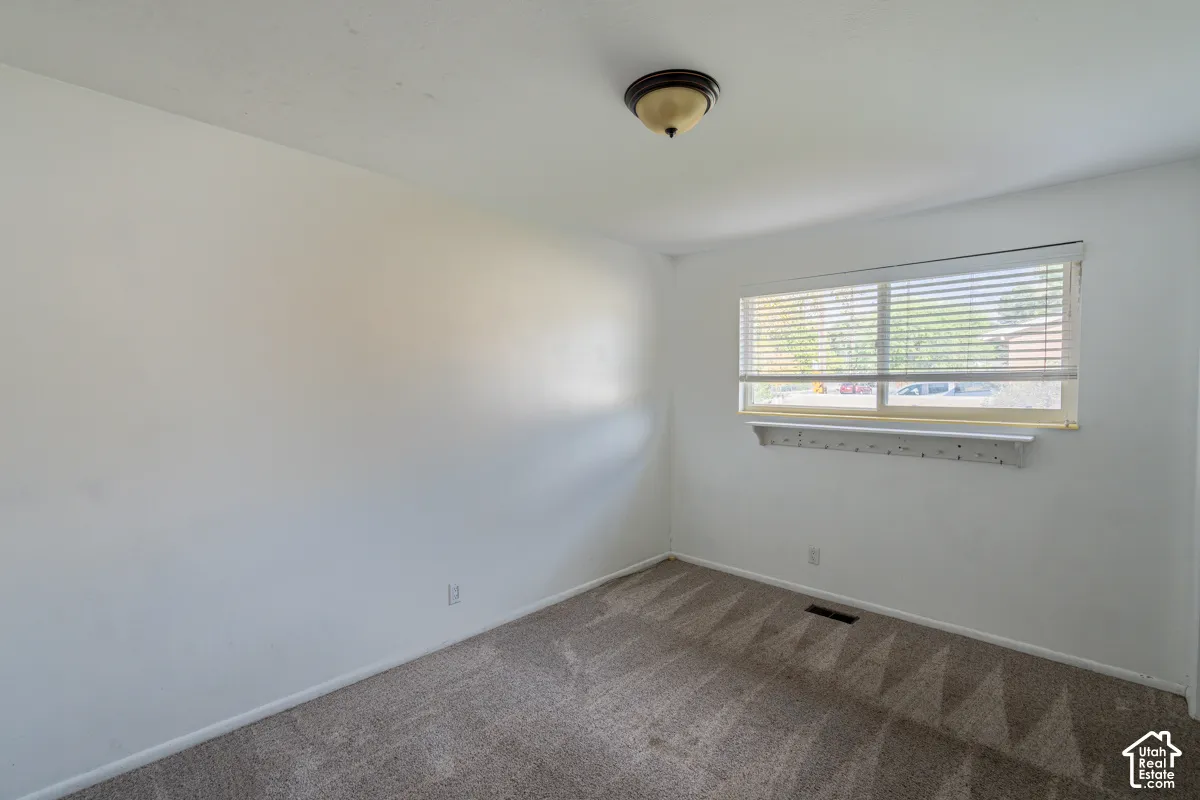 Neutral wall finish, single window with blinds, and flush-mount ceiling light