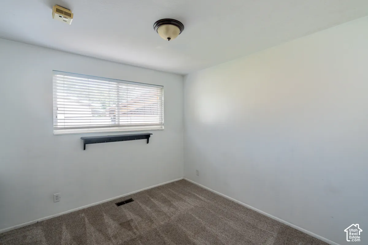 Recessed window with horizontal blinds, overhead ceiling light fixture, and wall-mounted shelf