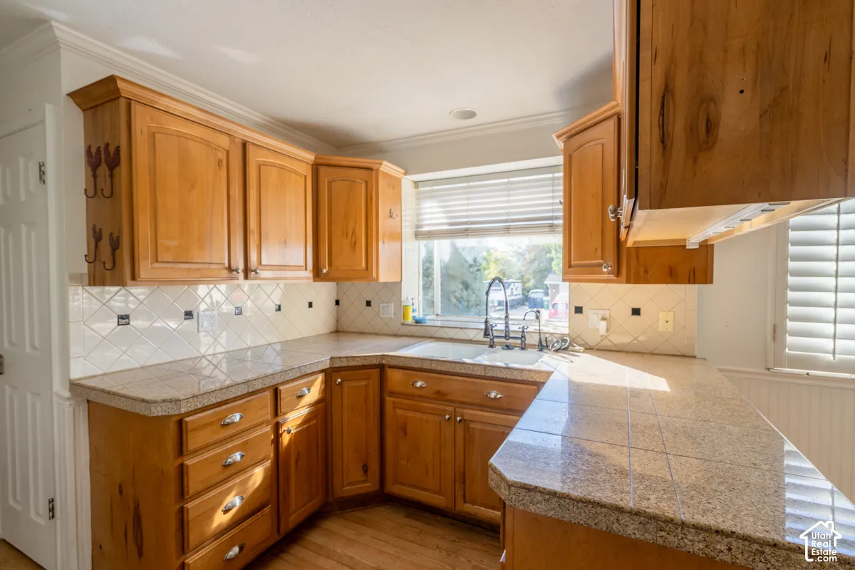 Wood-finish cabinetry paired with light-toned countertops and a tile backsplash