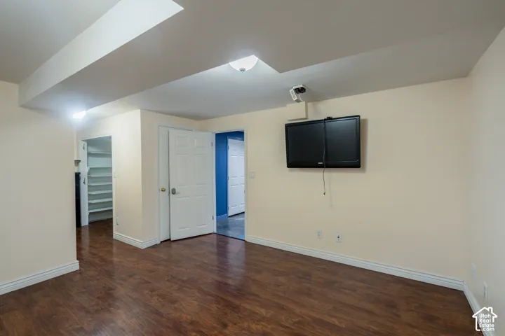 Wood-finish flooring, recessed lighting, and white baseboards