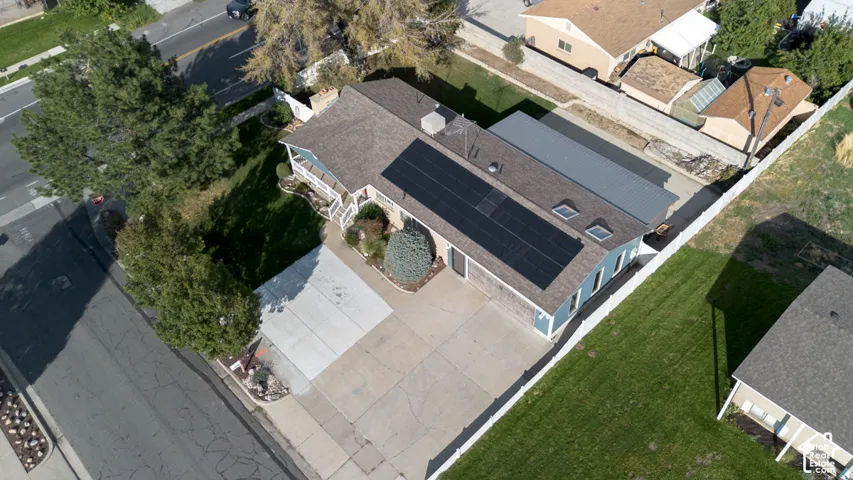 Pitched roof, front porch, solar panels, attached carport, and mature landscaping
