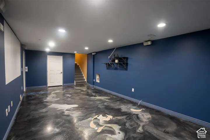 Recessed ceiling lighting illuminates the space featuring blue walls and a unique multi-toned flooring finish