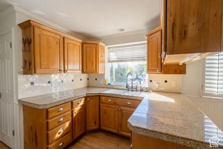Wood-finish cabinetry paired with light-toned countertops and a tile backsplash