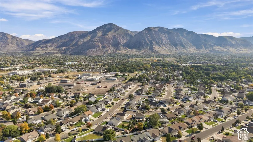 Residential area with established streets and mature landscaping, set against a mountainous backdrop