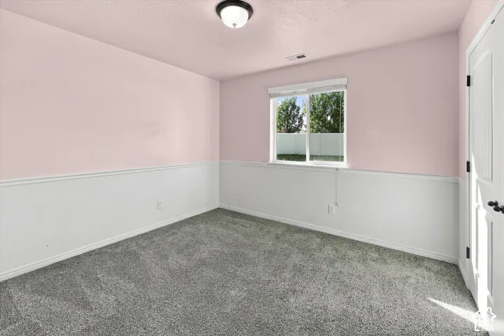 Recessed lighting, textured ceiling, two-tone wall treatment, window with exterior landscaping, and carpeted flooring
