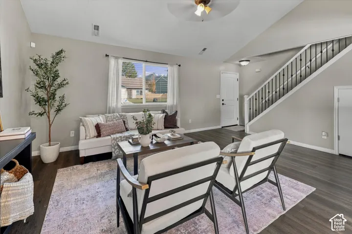 Open-concept living area featuring dark wood-finish flooring, recessed ceiling lighting, and large windows with natural light