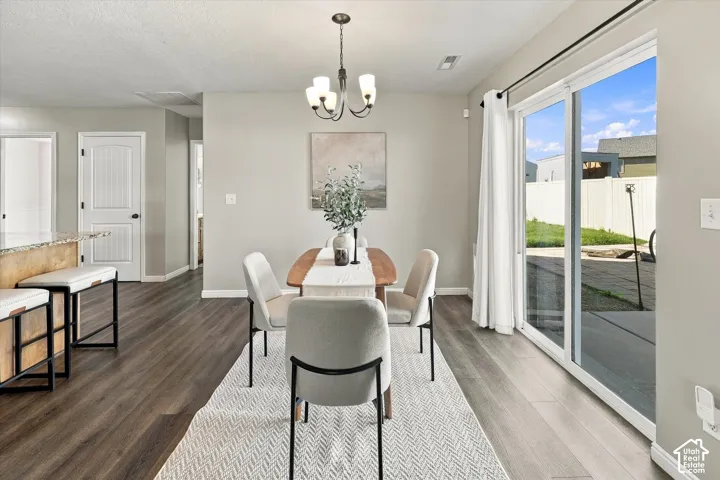 Wood-finish flooring throughout, sliding glass door leading to the exterior, and a chandelier with a matte black finish