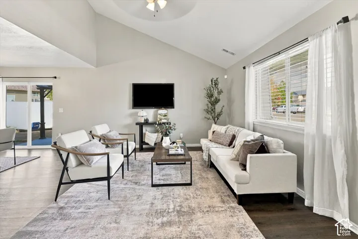 Vaulted ceilings, wood-finish flooring, ceiling fan, and sliding glass door