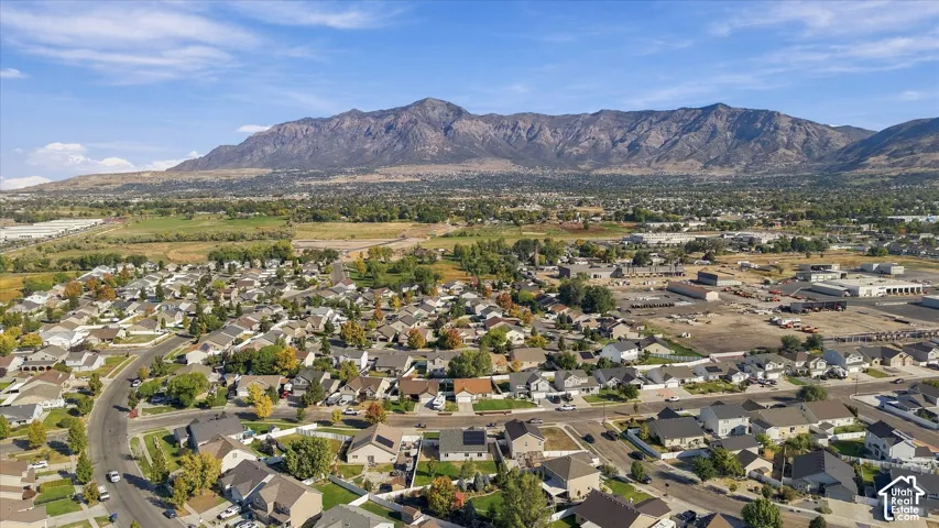 Expansive aerial perspective showcasing a residential development with surrounding open land and a prominent mountain range backdrop