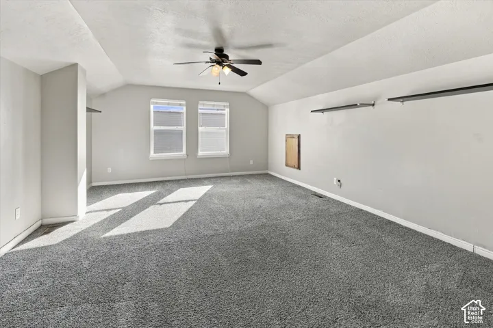 Bonus room upstairs with two windows, shelving, ceiling fan