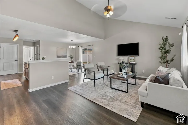Vaulted ceiling with an attached ceiling fan, wood-finish flooring, a ceiling light and delightful space.