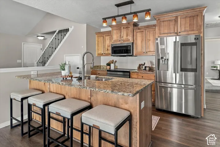 Kitchen with wood-finish cabinetry, granite countertops, and stainless steel appliances