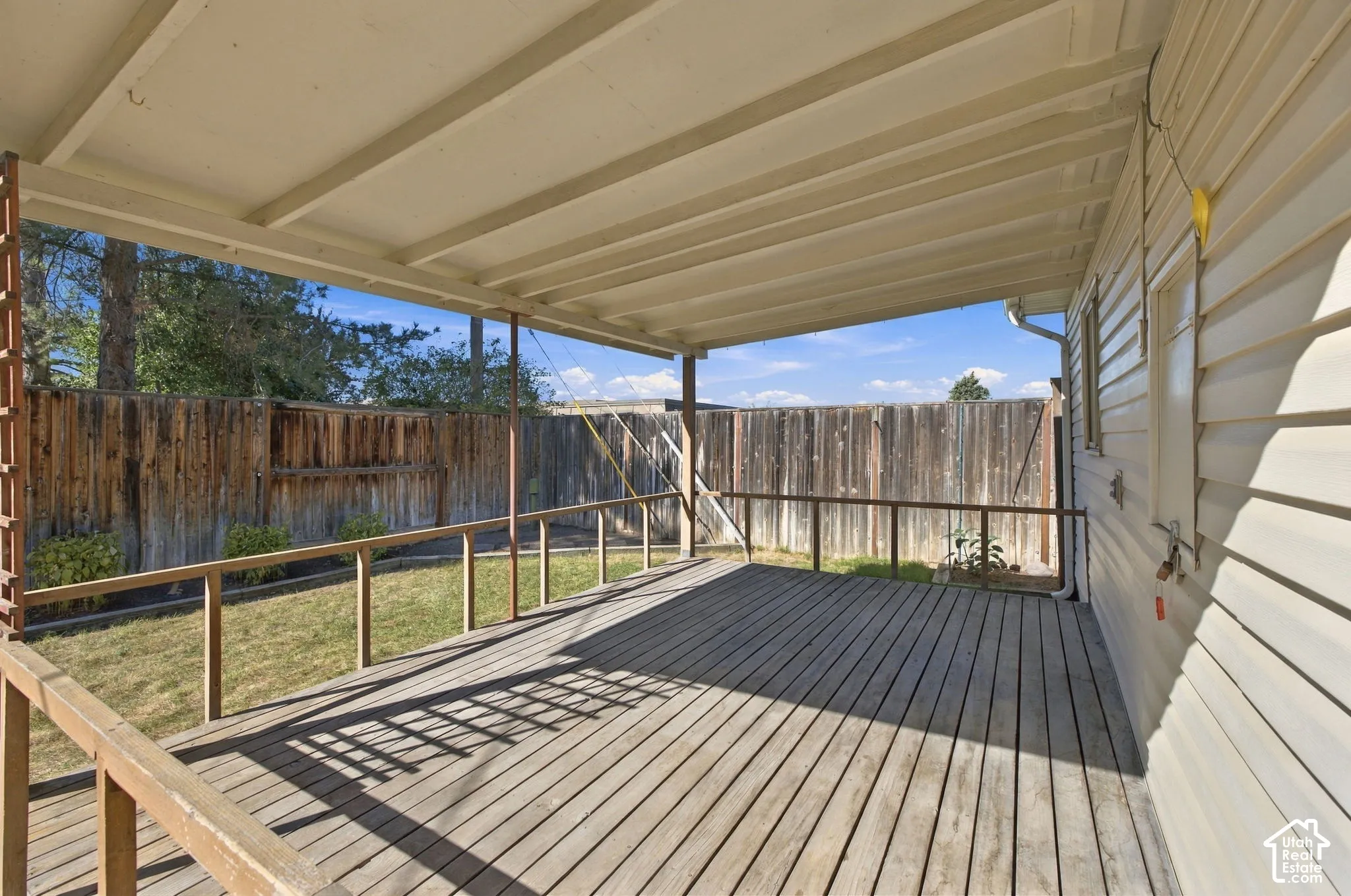 Expansive covered deck with wood flooring and wood railing