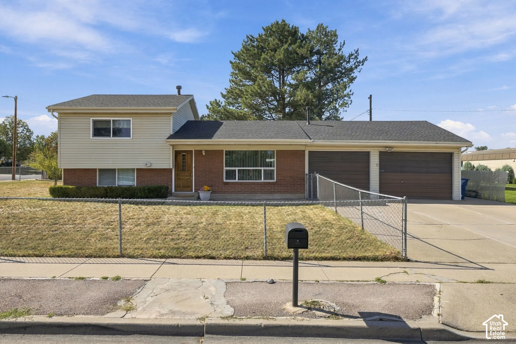 Brick and siding exterior with a dark shingle roof