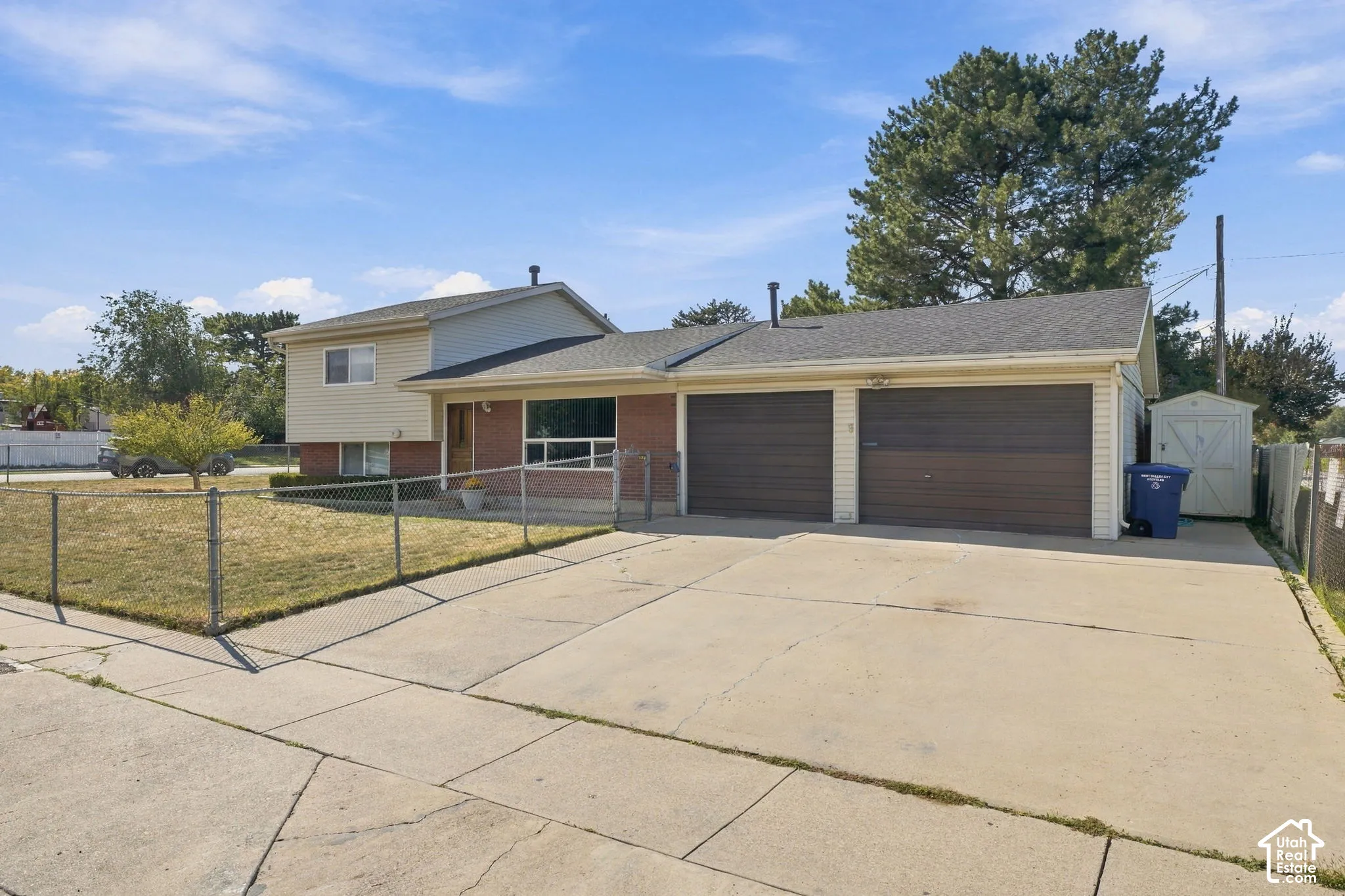 Concrete driveway and two-car garage with dark brown doors