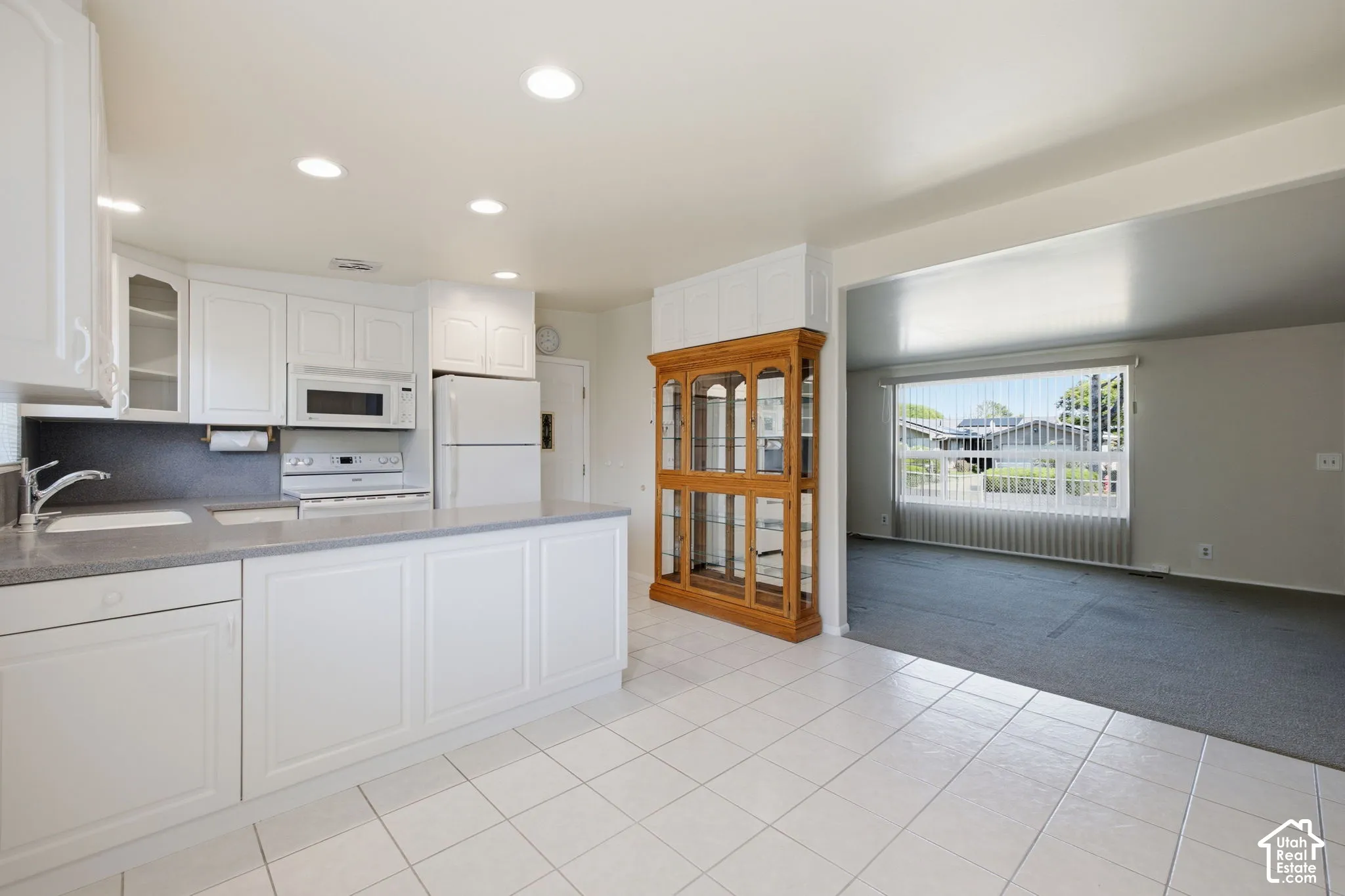 Kitchen featuring white cabinetry, gray countertops, recessed lighting, and tile flooring