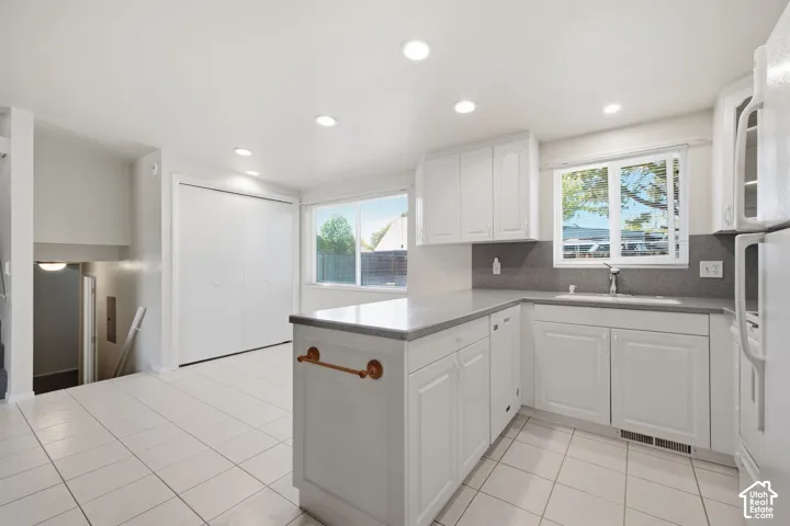 Kitchen featuring white cabinetry, gray countertops, tile flooring, and recessed lighting