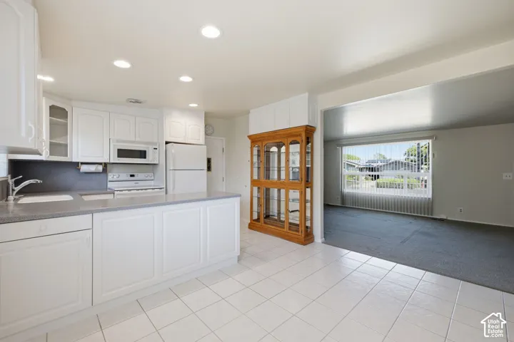 Kitchen featuring white cabinetry, gray countertops, recessed lighting, and tile flooring