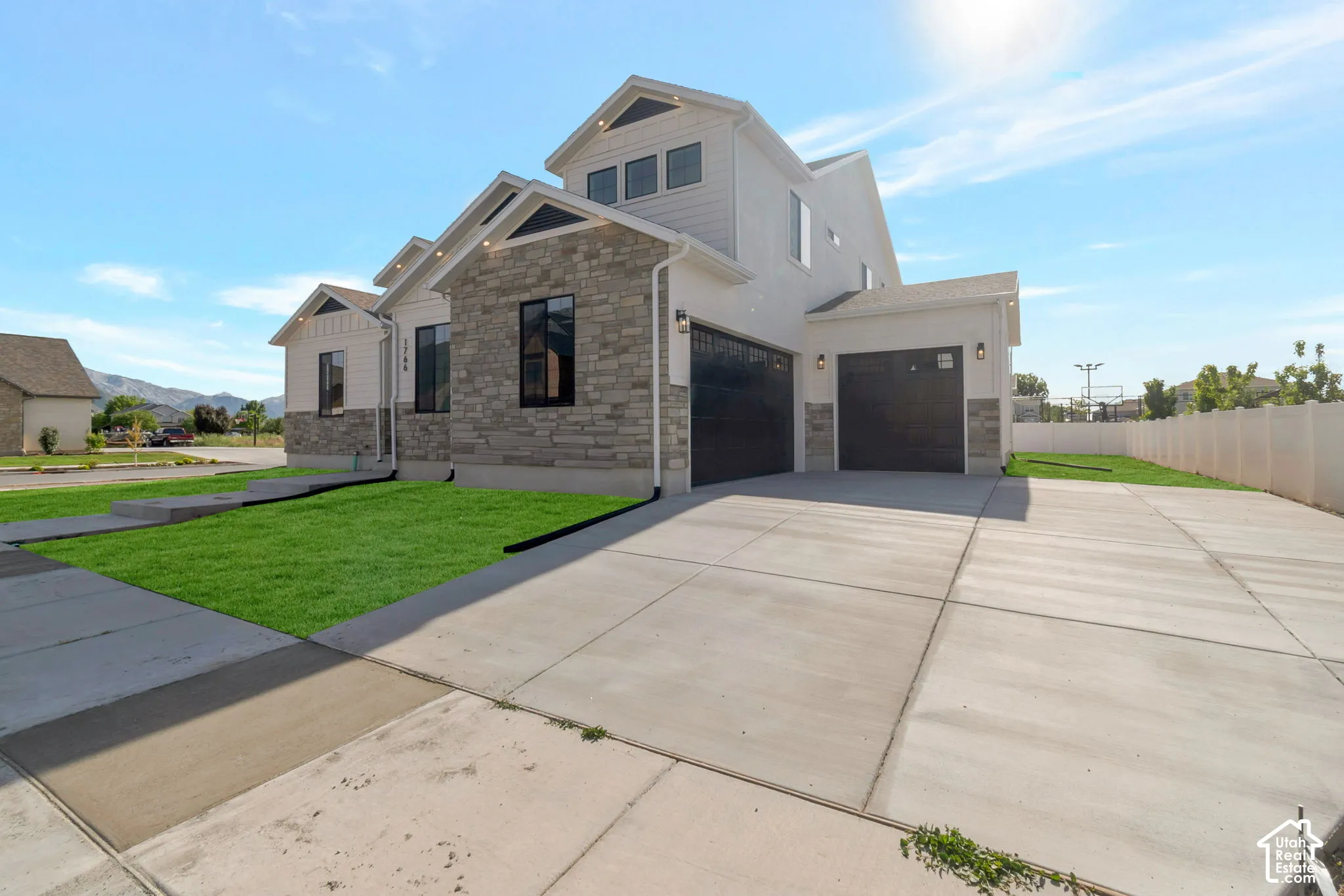 Contemporary exterior featuring light-toned siding and stone accents