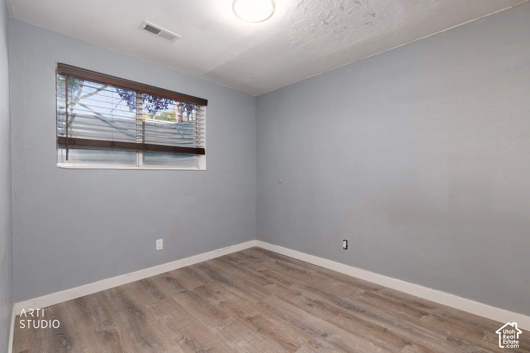 Wood-finish flooring, light gray wall tones, and white trim