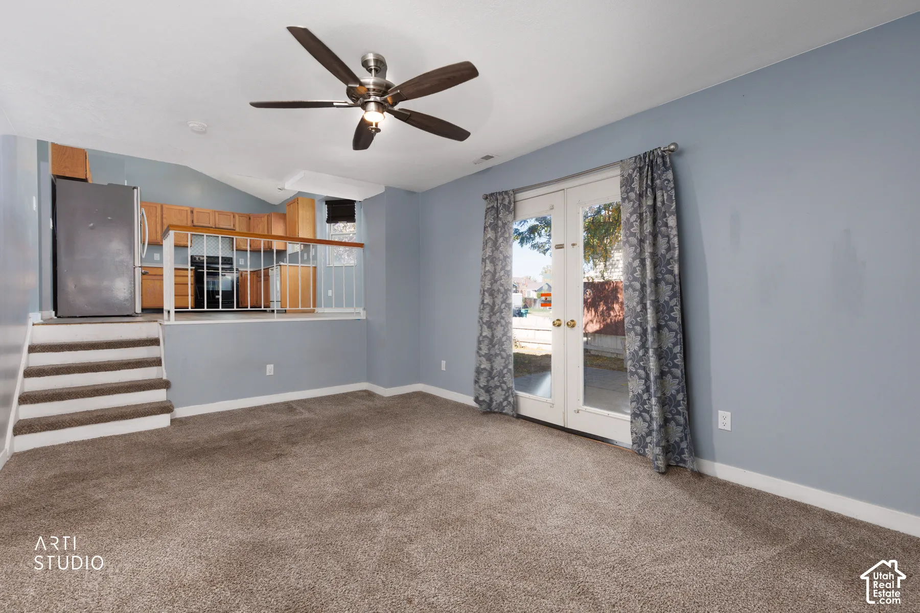 Carpeted living area with a vaulted ceiling and ceiling fan