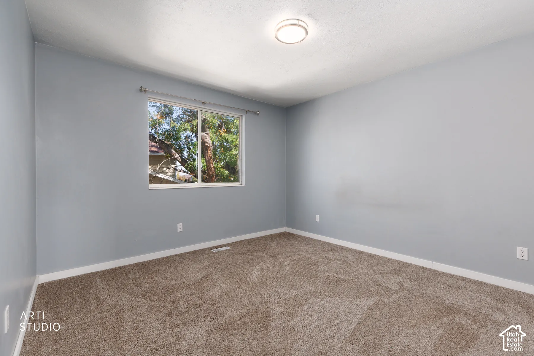 Neutral-toned carpeting, light gray walls, white trim, recessed window, and flush-mount ceiling light
