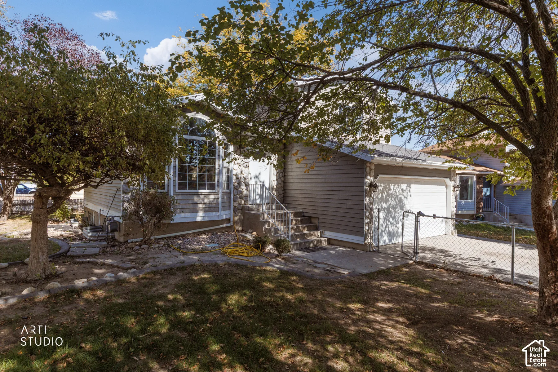 Exterior with horizontal siding, stone facade accents, arched window, and attached garage