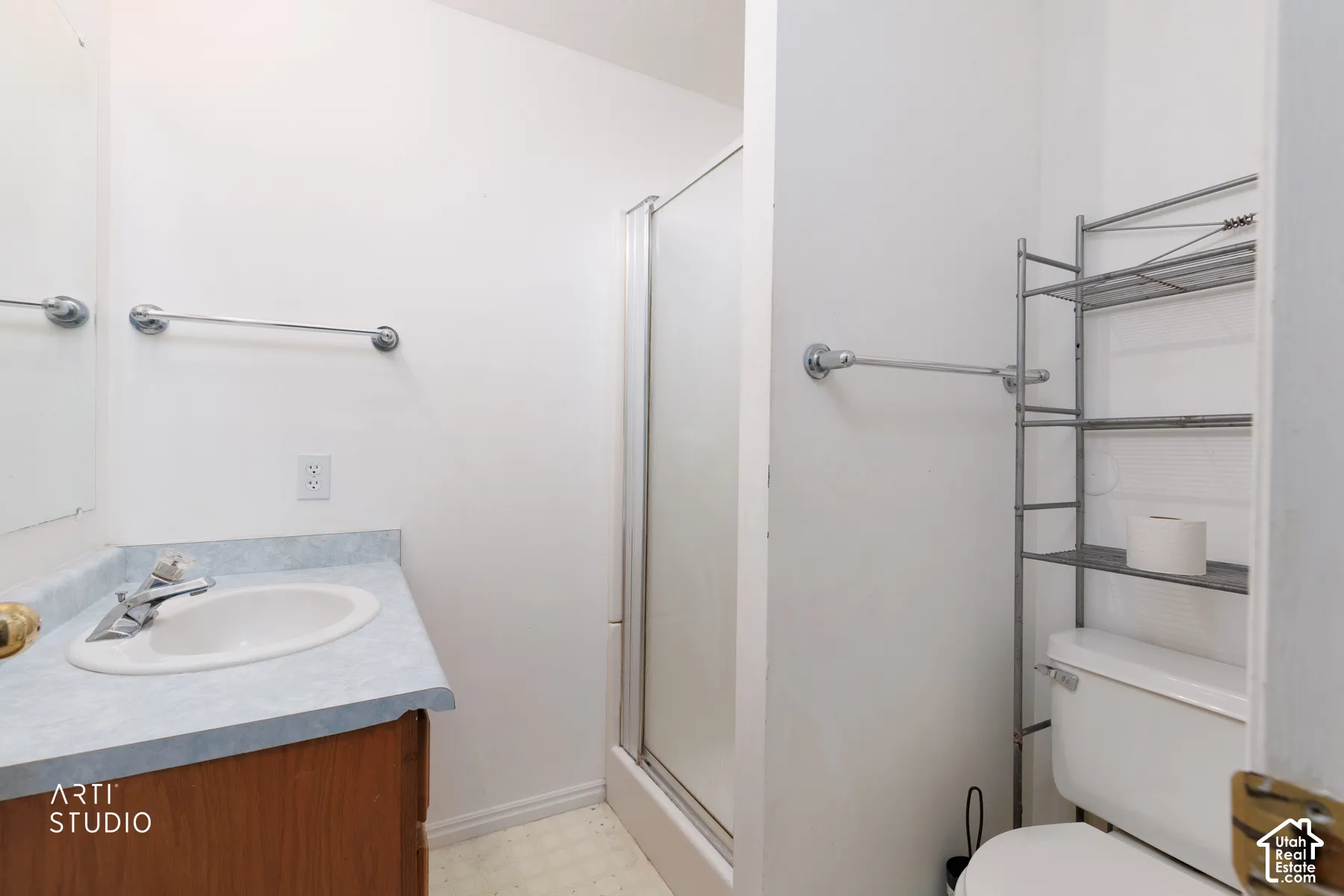 Full bathroom with a shower enclosure, wood-finish vanity, and a light-toned countertop