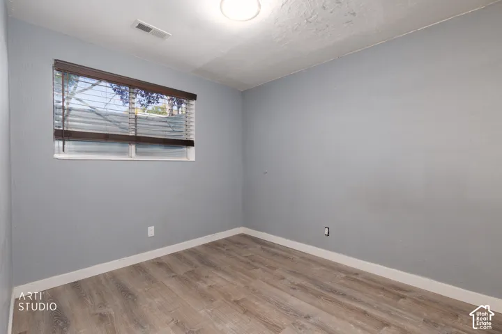 Wood-finish flooring, light gray wall tones, and white trim