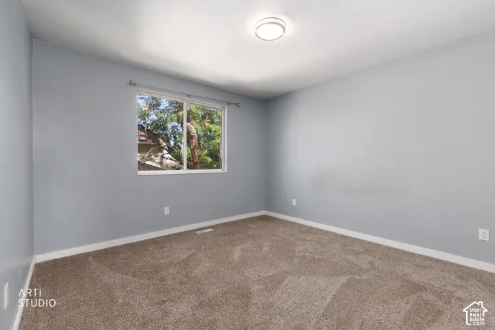 Neutral-toned carpeting, light gray walls, white trim, recessed window, and flush-mount ceiling light
