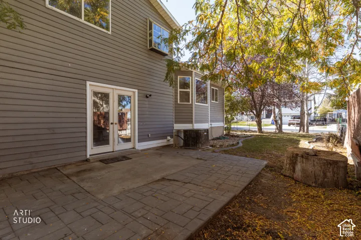 Patio with paver and concrete surfaces, double glass-paneled doors, and exterior siding