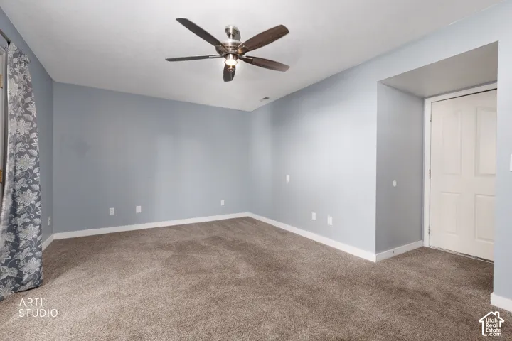 Recessed door frame with a paneled door, ceiling fan, and carpet flooring