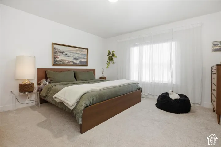Carpeted flooring, recessed lighting, and a large window with sheer drapery