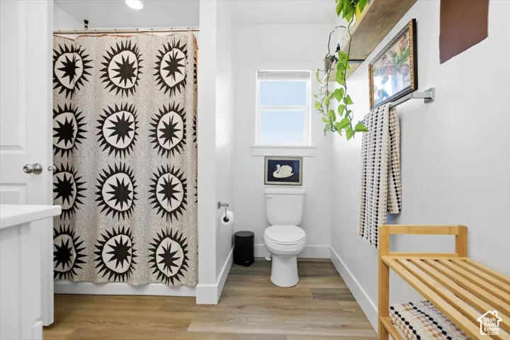 Wood-finish flooring, white walls, built-in shelving, and a window providing natural light