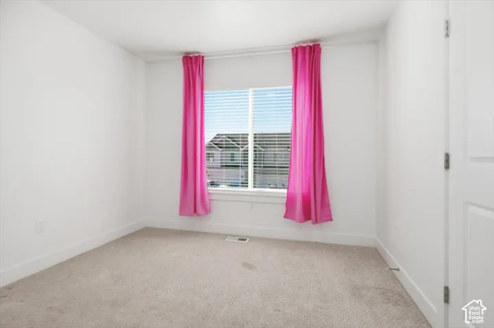 Neutral carpet flooring, white walls, and a window with horizontal blinds