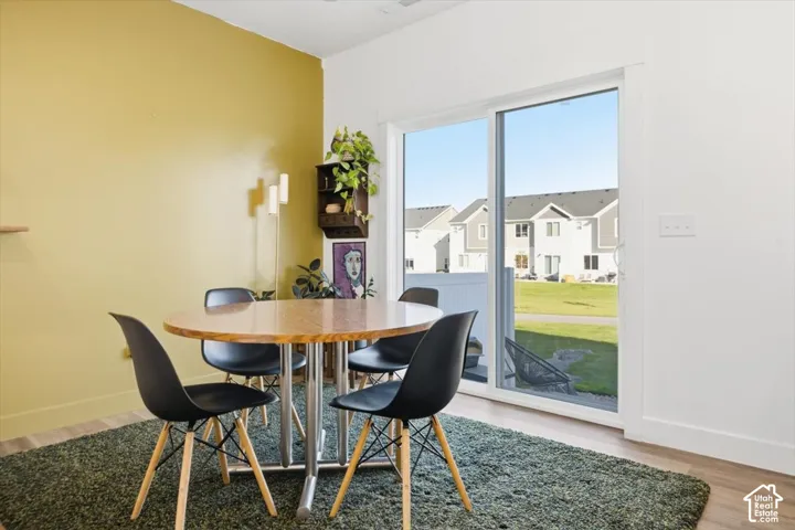 Sliding glass door, wood-finish flooring, and white baseboards