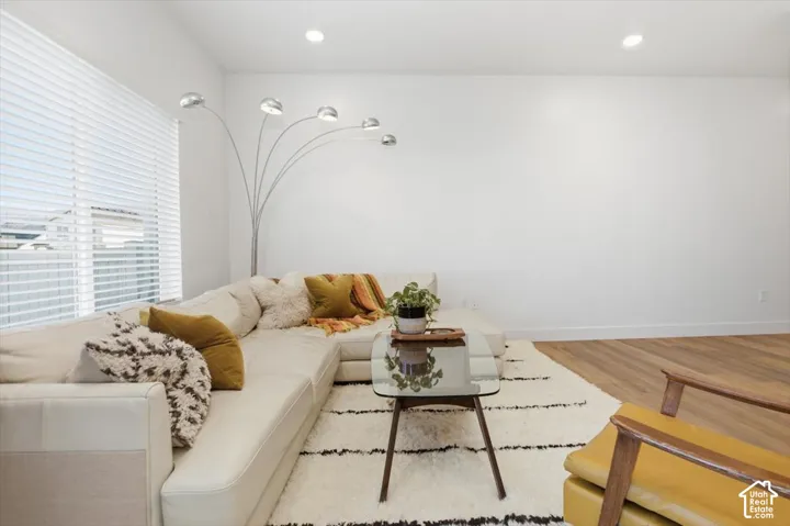 Recessed lighting, wood-finish flooring, and white walls
