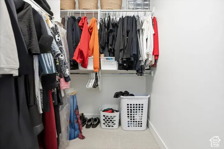 White shelving system with multiple hanging rods and an upper storage shelf