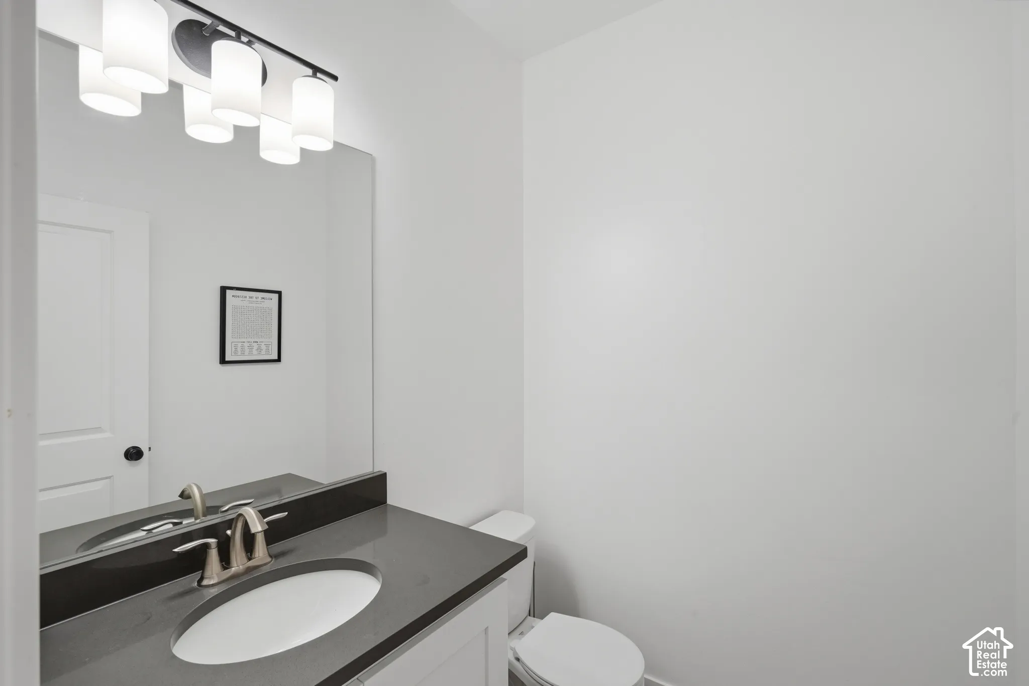Vanity with a solid surface countertop, undermount sink, and brushed nickel faucet