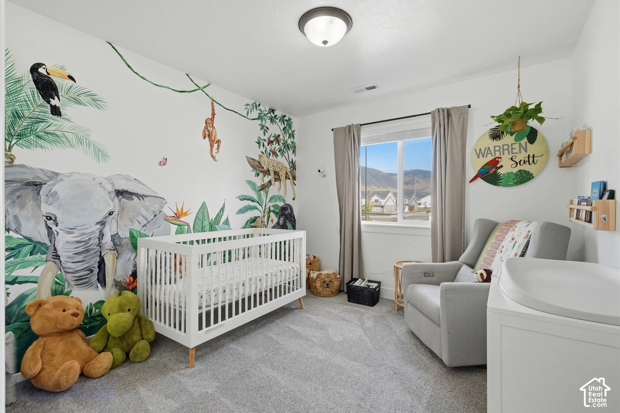 Carpeted flooring with a large window featuring a mountain backdrop and a flush mount ceiling fixture