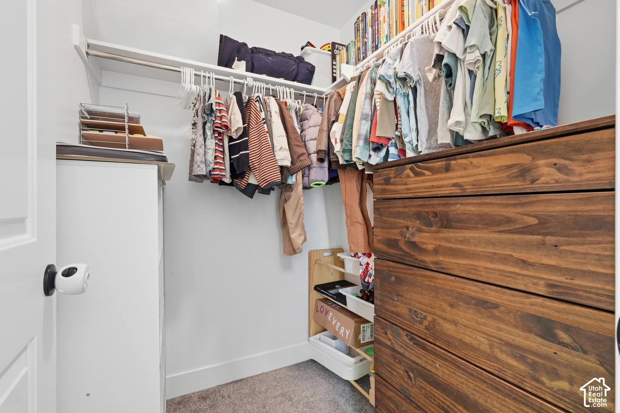 Built-in wood-finish dresser, white shelving, and hanging rods provide ample storage