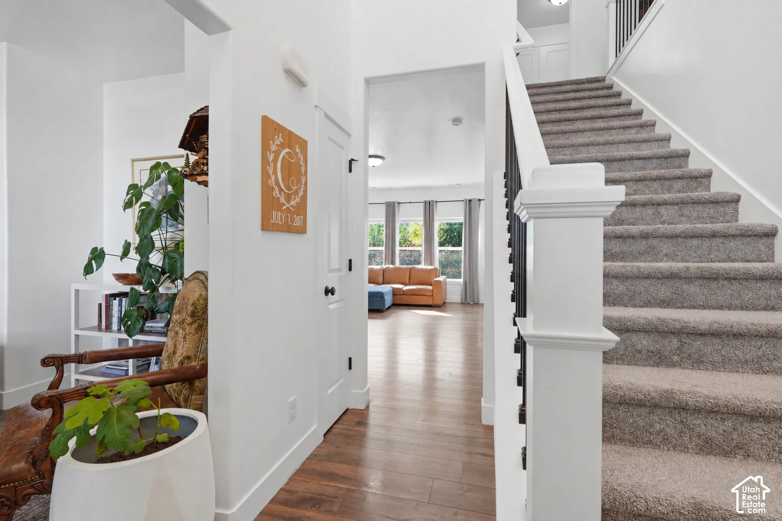 Carpeted staircase with dark metal balusters and white newel post