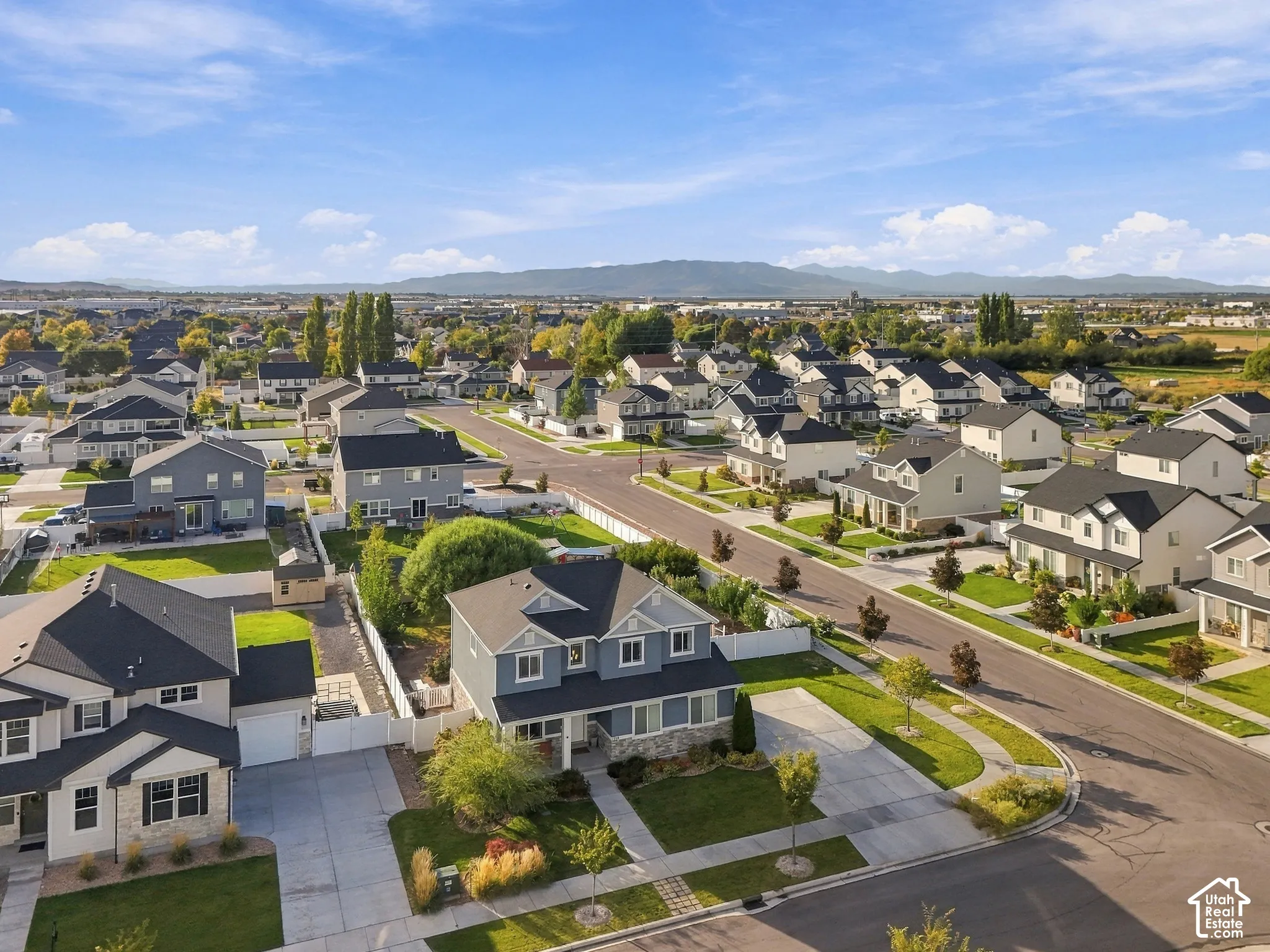 Residential neighborhood with paved streets and sidewalks, featuring landscaped front yards and mature trees