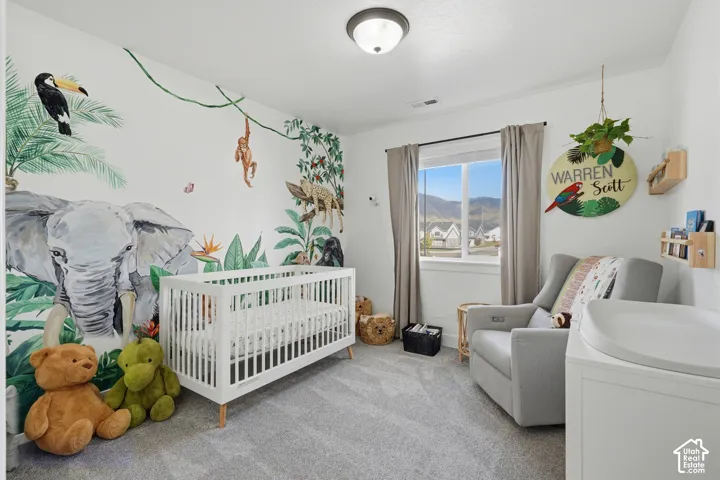 Carpeted flooring with a large window featuring a mountain backdrop and a flush mount ceiling fixture