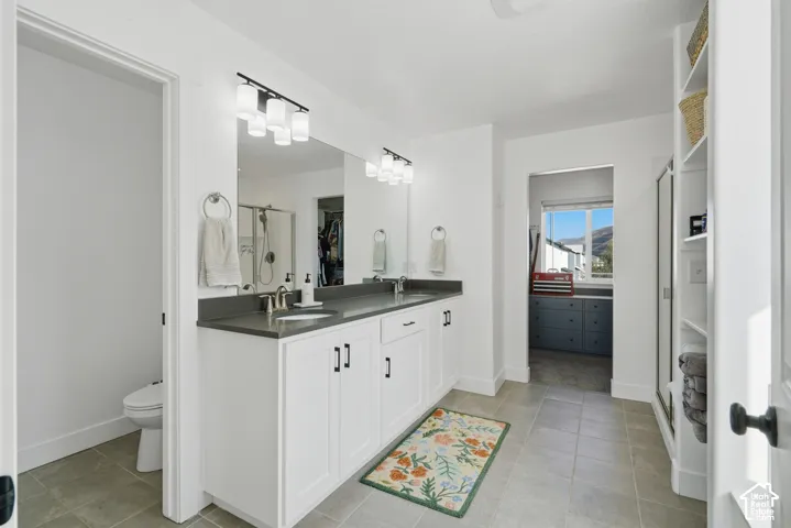 Dual vanity with white cabinetry, dark countertop, and matte black fixtures