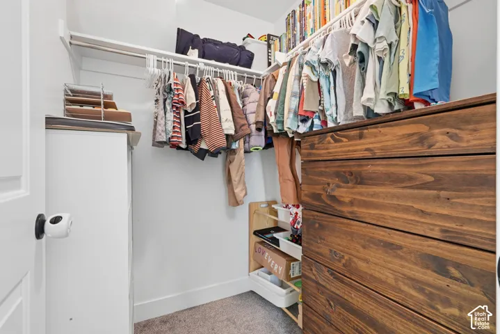Built-in wood-finish dresser, white shelving, and hanging rods provide ample storage