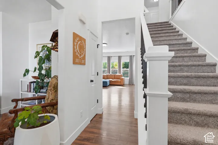 Carpeted staircase with dark metal balusters and white newel post