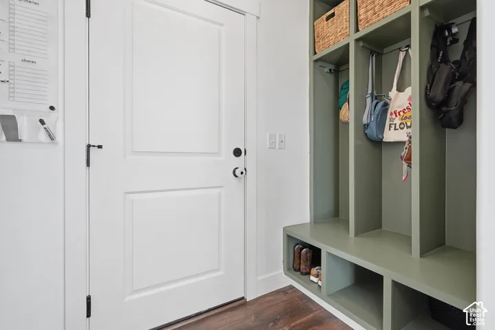 Built-in mudroom storage with open shelving, integrated bench seating, and wood-finish flooring