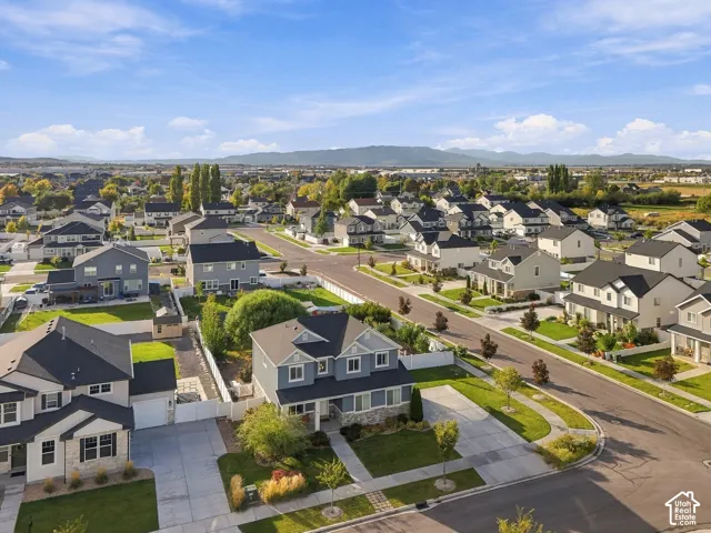 Residential neighborhood with paved streets and sidewalks, featuring landscaped front yards and mature trees