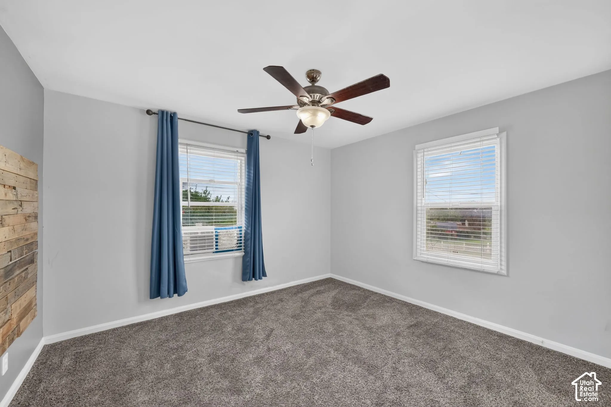Spacious room featuring neutral grey walls and plush grey carpeting